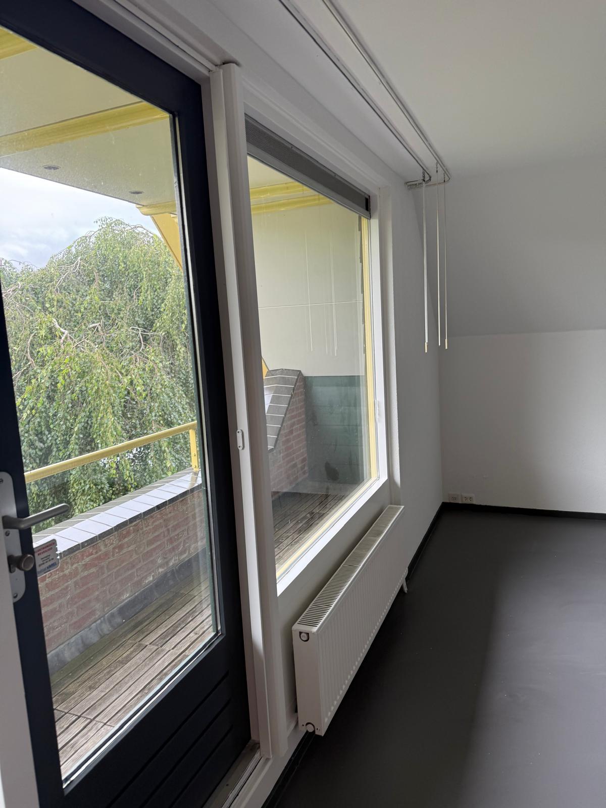 Slaapkamer met geschilderde balkondeur en kozijnen