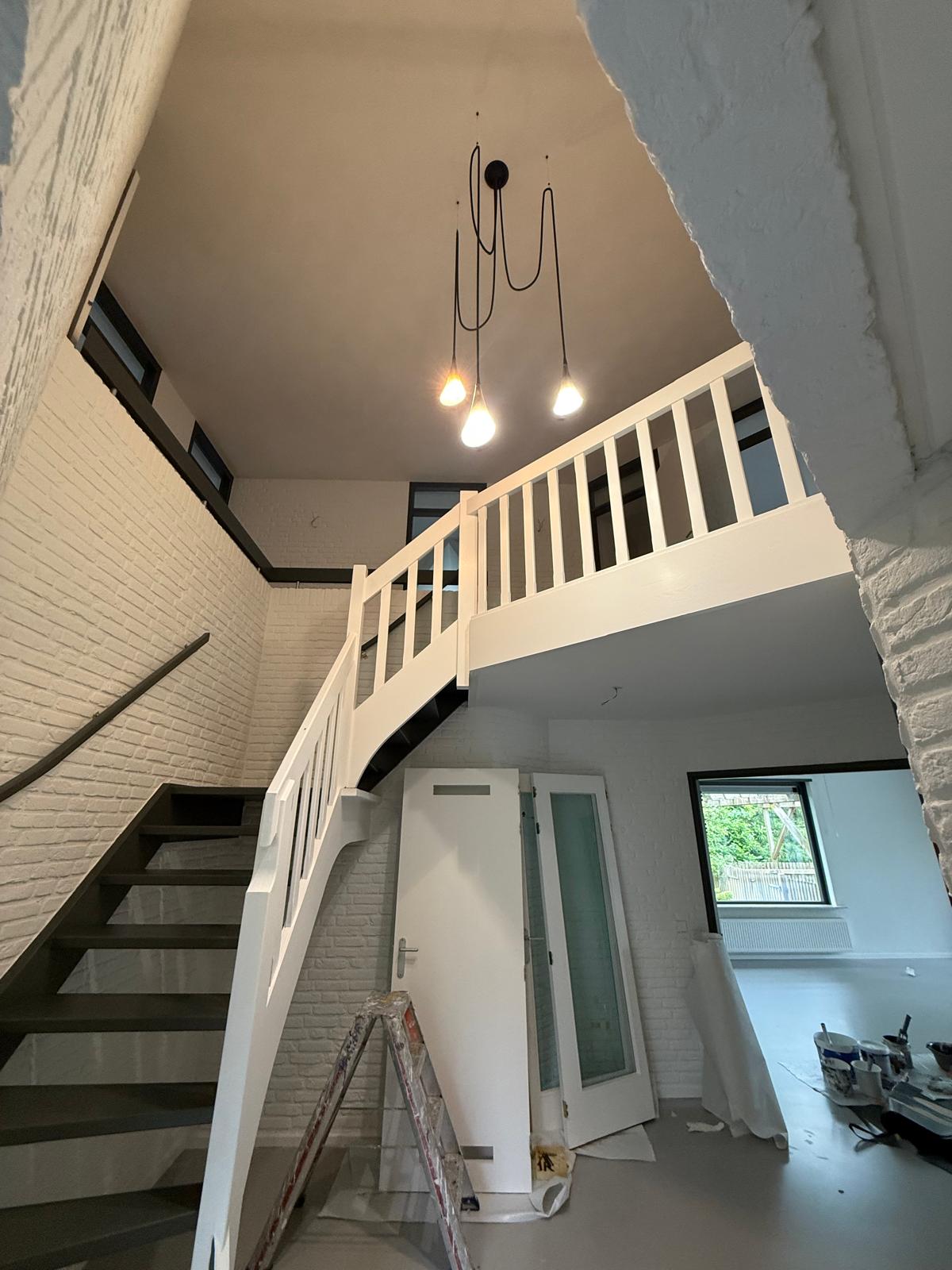 Trappenhuis met wit geschilderde balustrade en lichtpunt